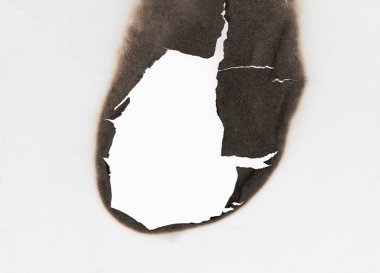 Beyaz kağıtta izole edilmiş yanmış bir delik. Yanan sınırlar kağıdı kapat