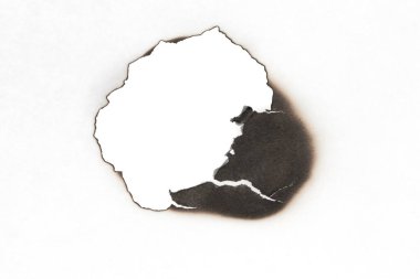 Beyaz kağıtta izole edilmiş yanmış bir delik. Yanan sınırlar kağıdı kapat
