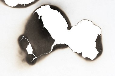 Beyaz kağıtta izole edilmiş yanmış bir delik. Yanan sınırlar kağıdı kapat