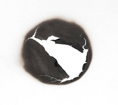 Beyaz kağıtta izole edilmiş yanmış bir delik. Yanan sınırlar kağıdı kapat