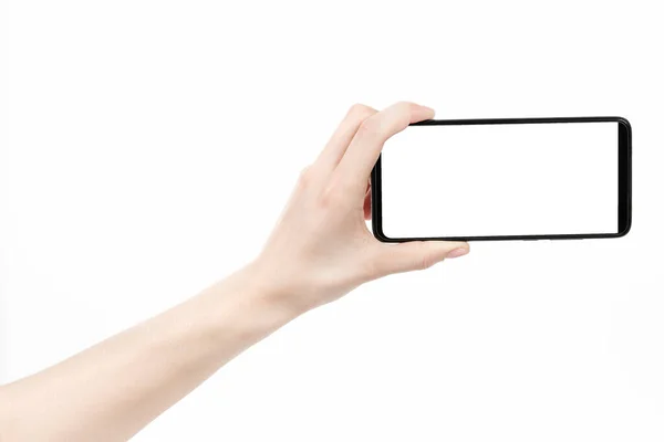空白の画面で黒の新しいスマートフォンを保持女性の手は白い背景を隔離しました 携帯電話のクリッピングパスを使って デザイナーにとって — ストック写真