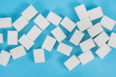 Mavi zemin üzerinde doğal beyaz şeker küpleri izole