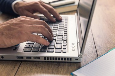 İş adamı ofiste defter üzerinde çalışıyor.