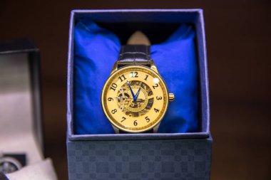 Koyu renkli masada şık bir kol saati. Moda aksesuarı