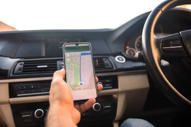 sürücü scree üzerinde navigasyon ile akıllı telefon tutuyor