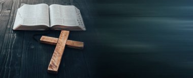 Masanın üzerinde tahta haç olan kutsal İncil.