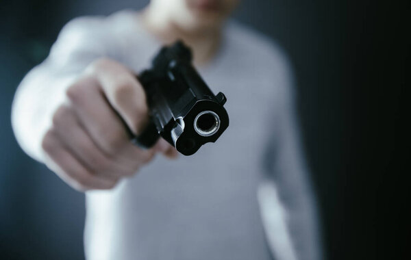 man hand gun on dark backgroun