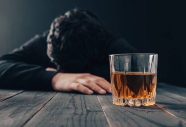 Masasında bir bardak alkol olan üzgün bir adam!