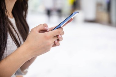 Sokakta akıllı telefon tutan kadın.