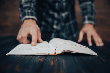 Genç adam karanlık sırtı hakkında kitap okuyor.