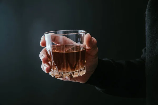 Człowiek Trzymający Szklankę Alkoholu Ciemnym Tle — Zdjęcie stockowe