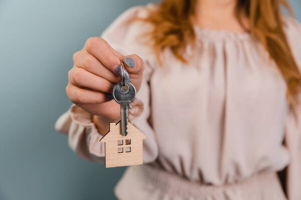 Real estate agents or house sales agents hand holding house ke