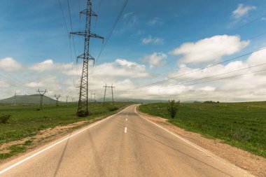 Gökyüzünün altındaki yolun yanındaki elektrik direği kulesi.