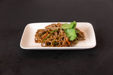 Popüler Malezyalılar beyaz tabakta kızarmış erişte pişiriyor.