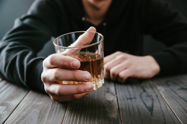 Yakından bir bardak viski tutan iş adamları.