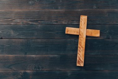 Christian cross on wooden background. Religion concep