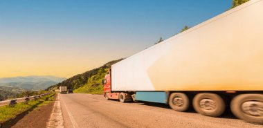 Beyaz bir kamyon ve altında beyaz bir karavan.