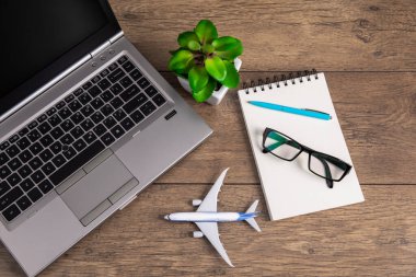 Ev masasını uçak modeli ve not defteri ile görüntüle