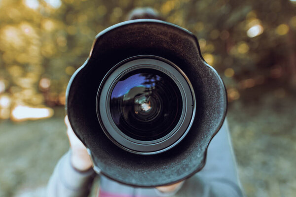 мужчина держит в руке фотоаппарат в натуральную величину