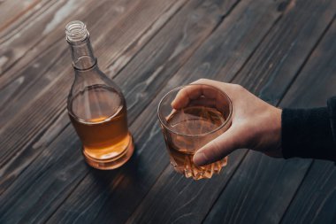 Yakından bir bardak viski tutan iş adamları.