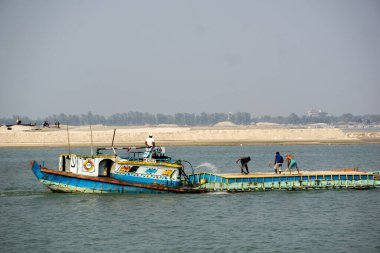 Boats loaded with sand are floating along the river. View of the river Padma in Bangladesh.