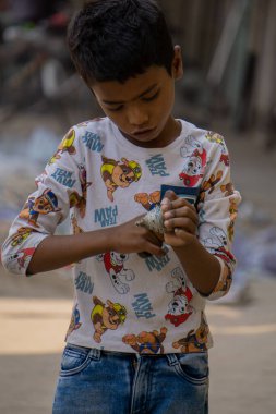 Latim is spinning in the child's hand. The children of the working people of the city run around and play like this after school. This is the traditional art of Bangladesh. The photo was taken on March 21, 2022.