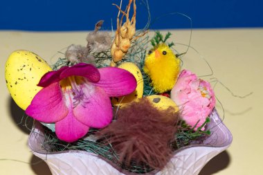 Paskalya yumurtaları ve çiçekler kasede, Mutlu Paskalya konsepti