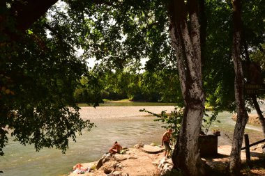 people near the river and amazing nature around