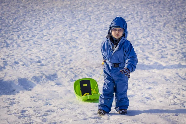 Boy pulling a sledge on snow — Stock Photo, Image