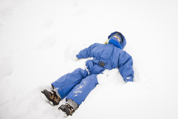 Boy lying in the snow