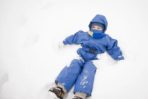 Boy lying in the snow — Stock Photo, Image