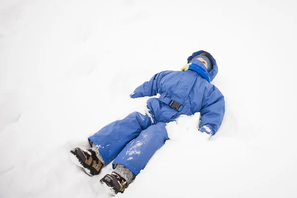 Boy lying in the snow — Stock Photo, Image