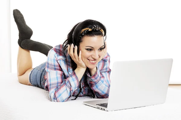 Woman listening to music with headphones and using computer lapt — Stock Photo, Image