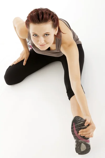 Fitness woman stretching her leg to warm up — Stock Photo, Image