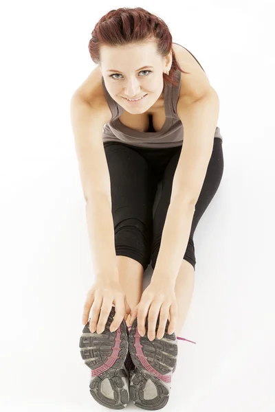 Fitness woman stretching her leg to warm up — Stock Photo, Image