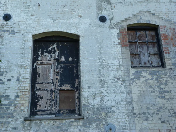 La puerta y la ventana de un viejo molino abandonado — Foto de Stock