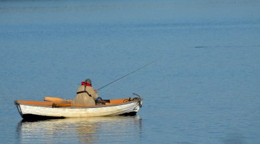 Sakin göl kenarında yalnız balıkçı