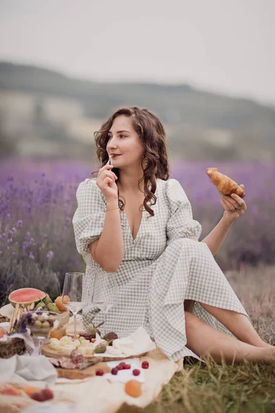 夏天薰衣草田一个拿着一篮子薰衣草的女孩一个享受野外野餐的女人 — 图库照片