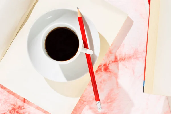 打开的书架上有红色铅笔 白色和红色背景的白咖啡 — 图库照片