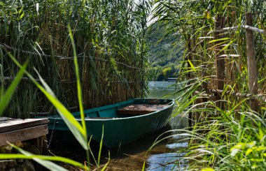 Small wooden boat between reed at the lake , leisuret time 