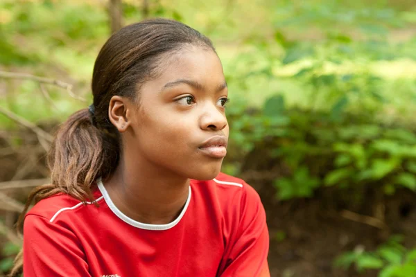 kayanın üzerinde oturan Afro-Amerikan kız