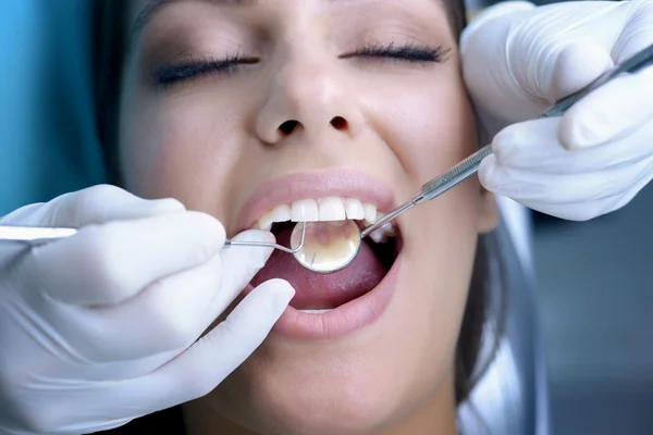 Mulher bonita visitando dentista para check-up dentário Fotografia De Stock