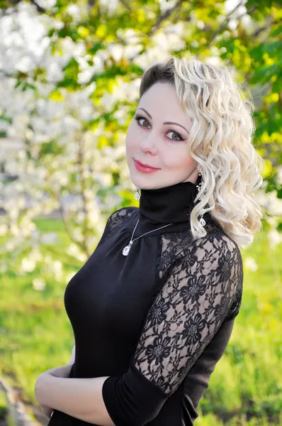 Mulher de vestido preto sobre pomar primavera — Fotografia de Stock