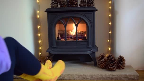 Frau Sitzt Warmer Kleidung Feuer Und Trinkt Tee Aus Weihnachtstasse — Stockvideo