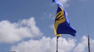 Barbados eyalet bayrağı, balıkçı teknesi direğinde rüzgarda sallanıyor.