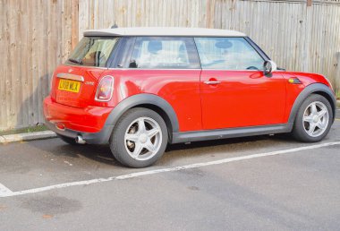 Red Mini Cooper car parked on street.
