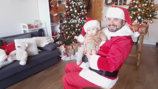 Kerstman Een Rood Witte Outfit Speelt Met Een Baby Tegen — Stockvideo