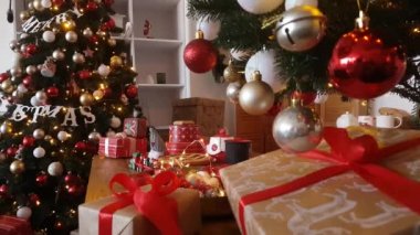 Noel pastaları, hediyeler ve süslü Noel ağaçlarının arka planında yanıp sönen ışıklar ve renkli toplarla dolu bir oyuncak tren.