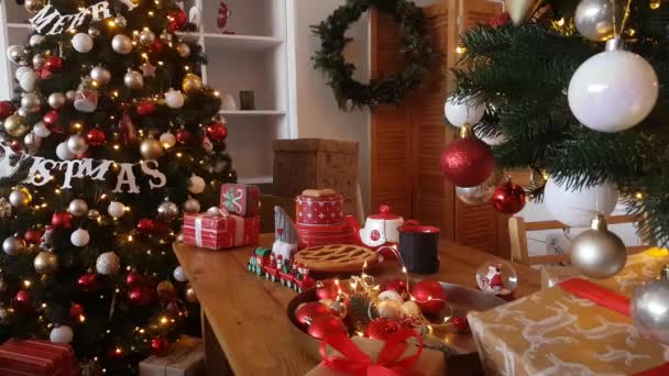 Tafel Met Kerstkoekjes Cadeaus Een Speelgoedtrein Tegen Achtergrond Van Versierde — Stockvideo