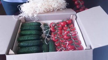 Tüketiciye sevkiyat için karton bir kutuda vişneli domates ve salatalık paketi